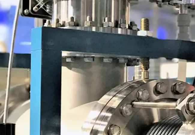 Close-up of industrial equipment used in non-clinical studies with radiolabeled compounds, featuring metallic components, bolts, and precision engineering.
