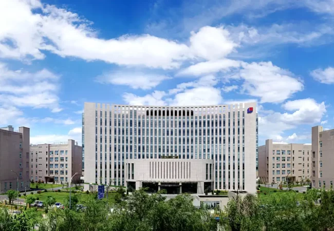 Pharmaron's Beijing site features a modern, multi-story office building with a curved façade, set against a clear sky.