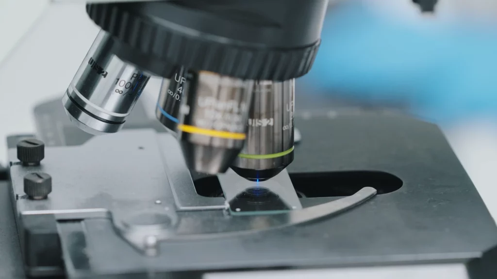 Close-up of a microscope lens focusing on a general toxicology slide, capturing detailed tissue analysis in a clinical lab setting.