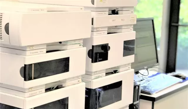 A stack of analytical instruments connected to a computer for metabolite profiling using Accelerator Mass Spectrometry (AMS) analysis.