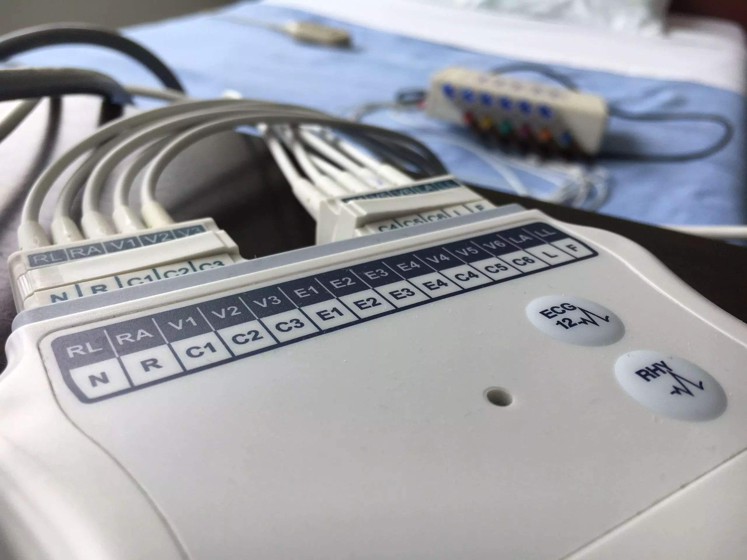 Close-up of an ECG machine's leads and control panel, used for monitoring heart activity in clinical or research settings.