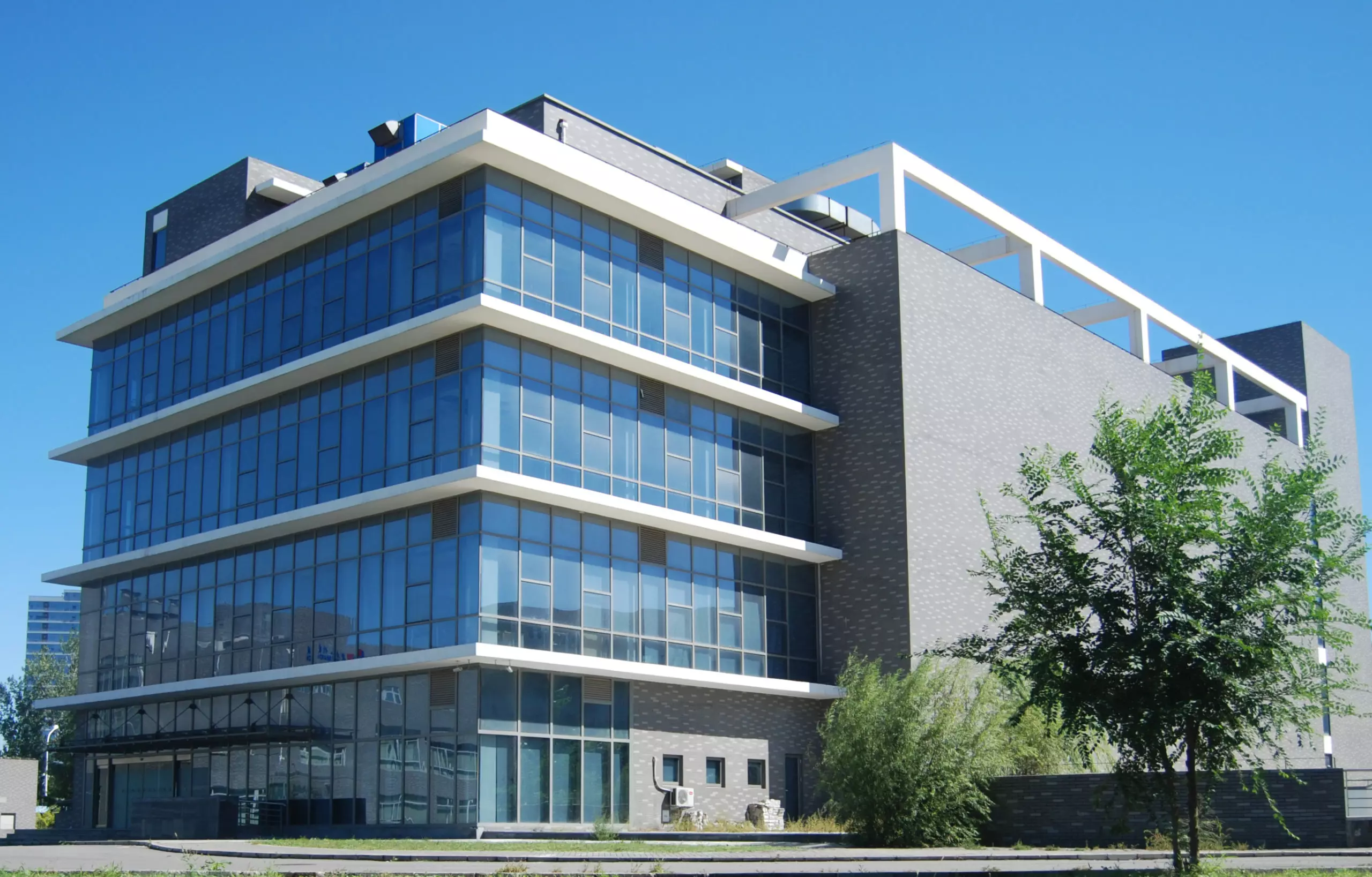 A modern, glass-fronted building under a clear sky, representing a facility that has passed a CFDA inspection for compliance and standards.
