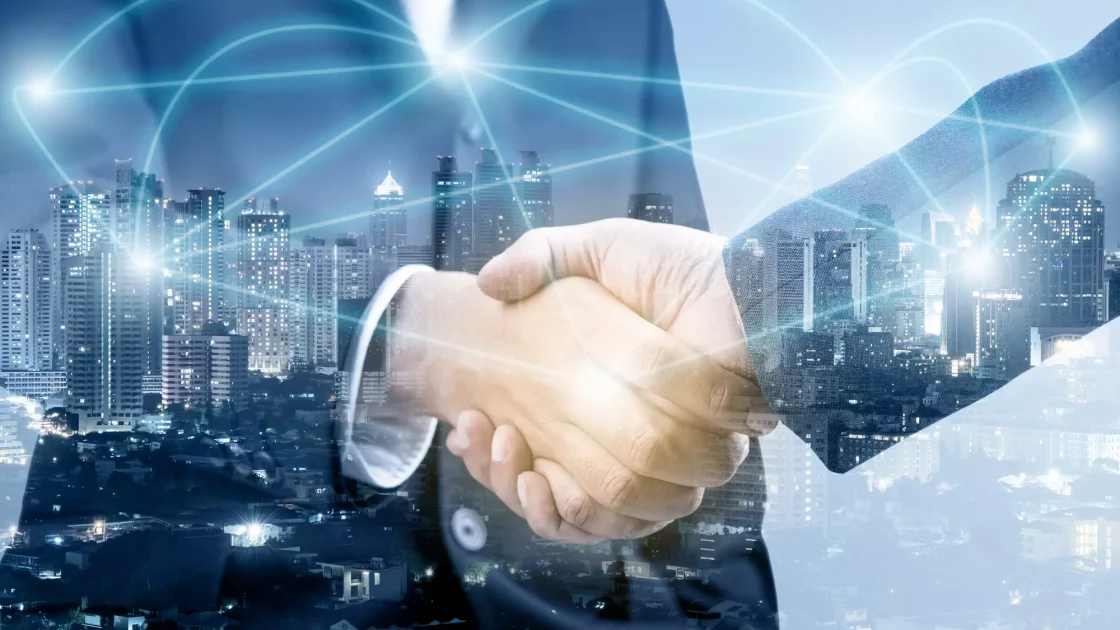 Two business professionals shaking hands against a cityscape background with digital connectivity lines, symbolizing company culture and collaboration.