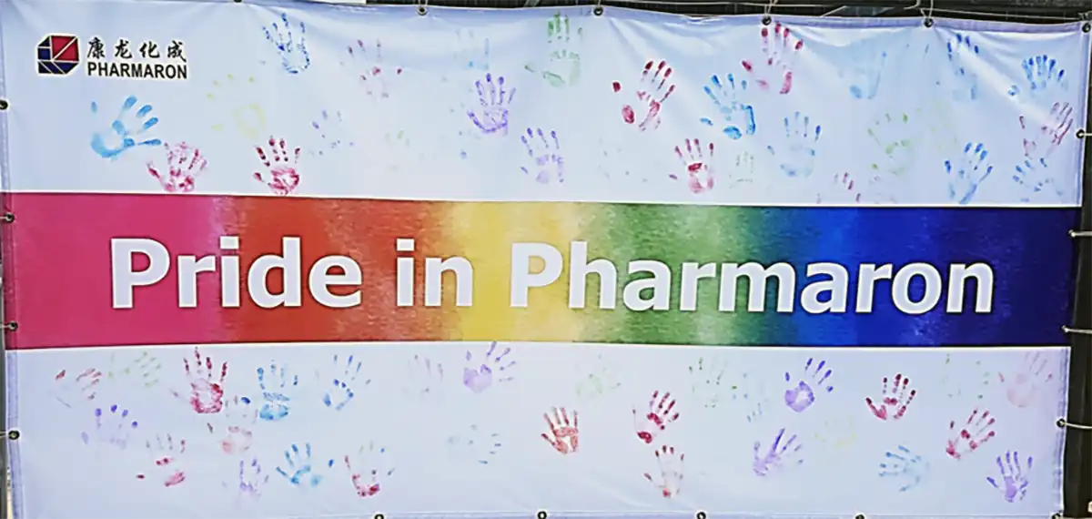 Banner with rainbow gradient and handprints reading "Pride in Pharmaron" highlighting inclusivity and support.