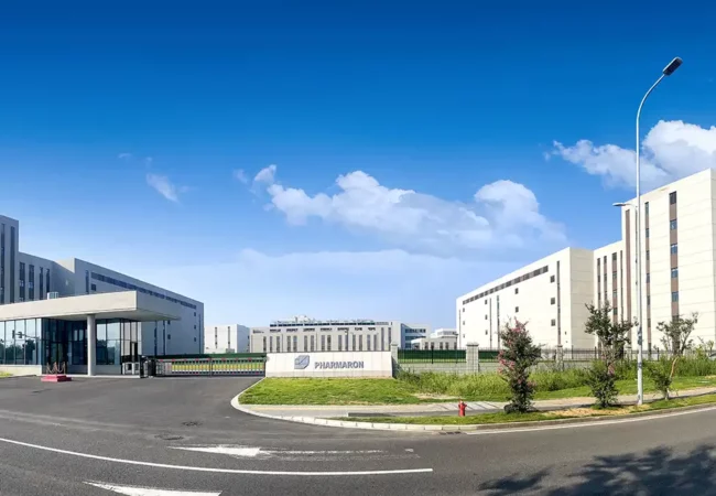 Pharmaron Ningbo Campus III featuring clean-lined research buildings, a gated entrance, and clear campus signage under a bright blue sky.