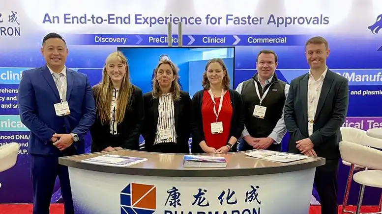 Six scientists stand at the Pharmaron booth under a banner reading “An End-to-End Experience for Faster Approvals” at the Phacilitate conference.